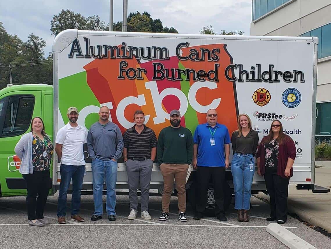donors and volunteers in front of the Aluminum Cans for Burned Children can collection truck
